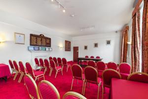 an empty room with red chairs and a table at Hotel Mariners in Haverfordwest