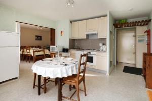 een keuken en eetkamer met een tafel en stoelen bij Découverte - Appt avec vue montagne in Gérardmer