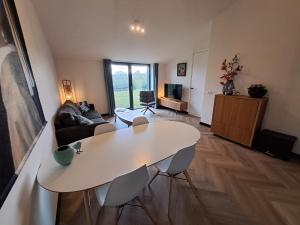 a living room with a white table and a couch at De Platwever 3B in Zelhem