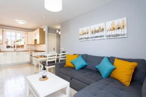 a living room with a gray couch and yellow pillows at Caletillas Waves & Pool in Candelaria