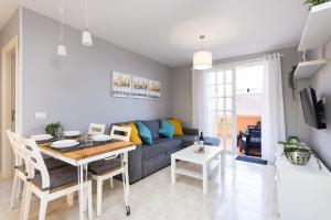 a living room with a blue couch and a table at Caletillas Waves & Pool in Candelaria