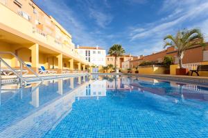 a large swimming pool in a hotel with buildings at Caletillas Waves & Pool in Candelaria
