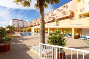 a resort with a swimming pool and a palm tree at Caletillas Waves & Pool in Candelaria