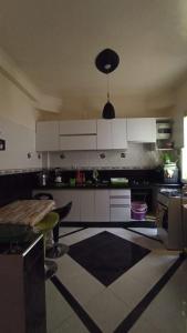 a kitchen with white cabinets and a black and white floor at alloggio in Agadir