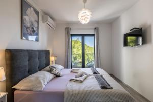 a bedroom with a bed with a window at Villa Perla Podstrana in Podstrana