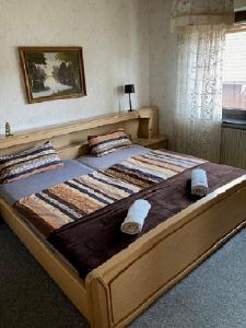 a large wooden bed with towels on it in a bedroom at Marja Ferienwohnung in Oberorke