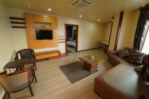 ein Wohnzimmer mit einem Sofa und einem Tisch in der Unterkunft Dvr Mansion in Kurnool