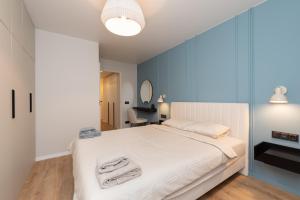 um quarto com uma cama branca e paredes azuis em Two-Story Urban Gem em Talin