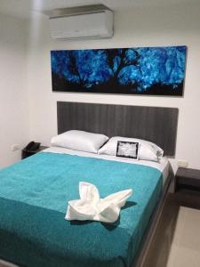 Onix Hotel في نيفا: غرفة نوم عليها سرير مع وردة بيضاء