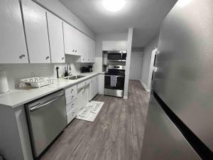 a kitchen with white cabinets and a stainless steel refrigerator at Cute Highland Park(Upper-A-Unit) in Calgary