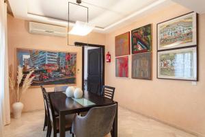een eetkamer met een tafel en een aantal schilderijen bij Palette of Dreams - Marrakech Centre in Marrakesh