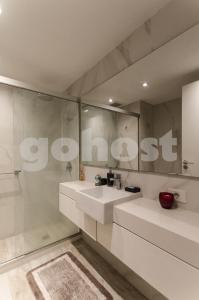 a bathroom with a white sink and a shower at Stunning, Fully Equipped Loft Paseo La Galeria in Asunción