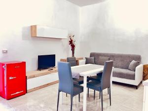 un soggiorno con tavolo, sedie e divano di Newly renovated apartment in the heart of Sorso a Sorso
