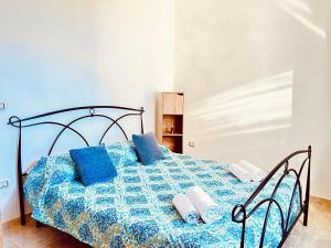 una camera con letto blu e cuscini blu di Newly renovated apartment in the heart of Sorso a Sorso