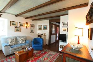 een woonkamer met een bank en een blauwe stoel bij Chalet San Valentino - Happy Rentals in Livigno