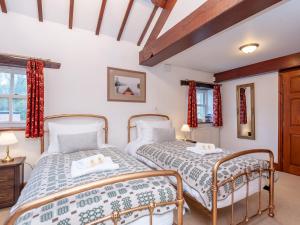 two beds in a room with two windows at Majestic Farmhouse Barn 8 Guests Pass the Keys in Pudsey