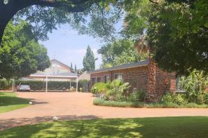 a brick house with a driveway in front of it at OR Tambo Int Airport Rudman B Self Catering Two Bedroom Home in Boksburg