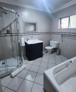 W łazience znajduje się umywalka, prysznic i toaleta. w obiekcie OR Tambo Int Airport Rudman B Self Catering Two Bedroom Home w mieście Boksburg