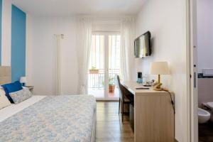 a bedroom with a bed and a desk and a television at B&B Il Saraceno in Sorrento