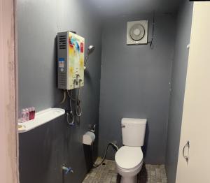 a small bathroom with a toilet and a phone at หลังสวน โฮมสเตย์ ดอยม่อนแจ่ม2 in Mon Jam