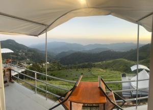 una mesa en un balcón con vistas a las montañas en หลังสวน โฮมสเตย์ ดอยม่อนแจ่ม2, en Mon Jam