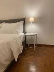 a bedroom with a bed and a table with a lamp at PHILOS Apartment in Old Town Xanthi in Xanthi