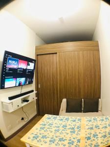 1 dormitorio con 1 cama y TV de pantalla plana en Spring Residences Affordable Staycation Bicutan Paranaque near NAIA Airport, en Manila