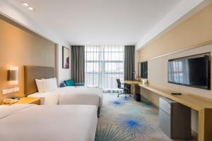 a hotel room with two beds and a flat screen tv at Holiday Inn Express - Liuyang Development Zone, an IHG Hotel in Liuyang