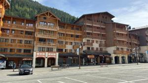 a large building on a street with a parking lot at Appartement coeur de station Valfrejus 6 pers in Modane