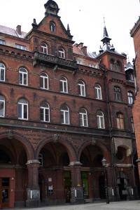 - un grand bâtiment en briques rouges avec des fenêtres blanches dans l'établissement Apartament Centrum Legnicy Janson, à Legnica