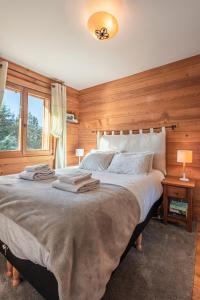1 dormitorio con 1 cama grande y paredes de madera en Beautiful 2 bed Chalet Morzine en Morzine