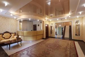 een grote lobby met een bank en een trap bij Park Hotel Aristokrat in Kostroma