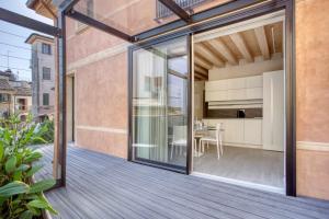 un balcone aperto con porte scorrevoli in vetro e zona pranzo di Do Pomi Suite a Treviso