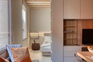 sypialnia z łóżkiem i telewizorem w pokoju w obiekcie Do POMI Suite w mieście Treviso