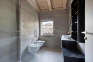 un bagno con un water, due lavandini e una finestra di Do Pomi Suite a Treviso Altre 74 foto