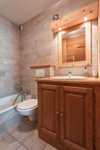 y baño con aseo, lavabo y espejo. en Beautiful 2 bed Chalet Morzine, en Morzine