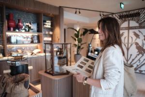 une femme debout dans un magasin en train de regarder un panneau dans l'établissement Boutique Hotel Blendin Bloemendaal aan Zee, à Overveen