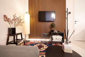 ein Wohnzimmer mit einem Sofa und einem TV an der Wand in der Unterkunft Verona Liberty Flats - Torricelle e Adige in Verona