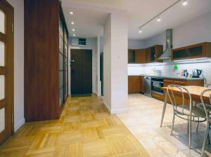 a kitchen with wooden floors and a table and chairs at Ursynow Apartament WAW Lanciego in Warsaw