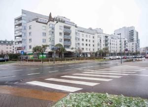 an empty city street with a large white building at Ursynow Apartament WAW Lanciego in Warsaw