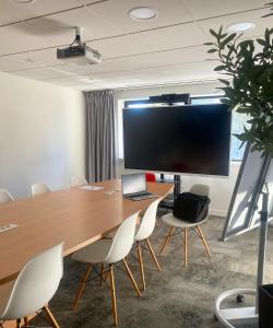 a conference room with a table and chairs and a large screen at ibis Nancy Centre Gare et Congres in Nancy