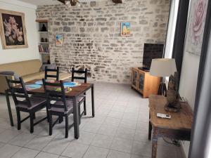 a living room with a dining room table and chairs at Souvenirs d'hier in Hyères