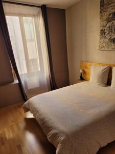 une chambre avec un grand lit et une fenêtre dans l'établissement Souvenirs d'hier, à Hyères