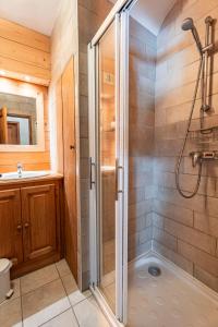 La salle de bains est pourvue d'une douche et d'un lavabo. dans l'établissement Beautiful 2 bed Chalet Morzine, à Morzine