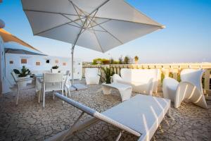 un patio con tavolo, sedie e ombrellone di Case di Torre Pali a Torre Pali