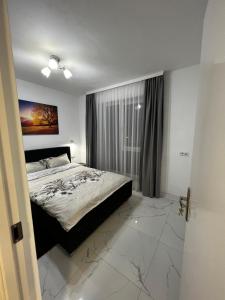 a bedroom with a bed and a large window at Cozy place in Baia Mare