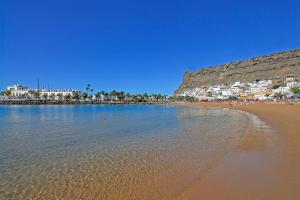 a beach with a group of people on the sand at Apartamentos Cordial Mogán Paraíso in Puerto de Mogán +23 photos