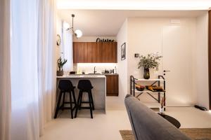 eine Küche und ein Wohnzimmer mit einer Theke und Stühlen in der Unterkunft Verona Liberty Flats - Torricelle e Adige in Verona