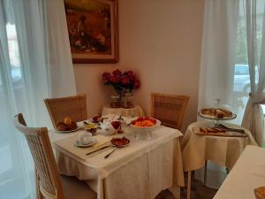 un tavolo con due sedie e un tavolo con il cibo sopra di Hotel Altea a Lido di Jesolo