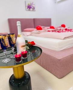 Habitación con cama y mesa con 2 copas de vino en Carpe Diem Privat Guesthouse, en Hermina-major